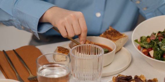 A close-up of a dining setup featuring soup, salad, and elegant tableware, creating a refined dining atmosphere.